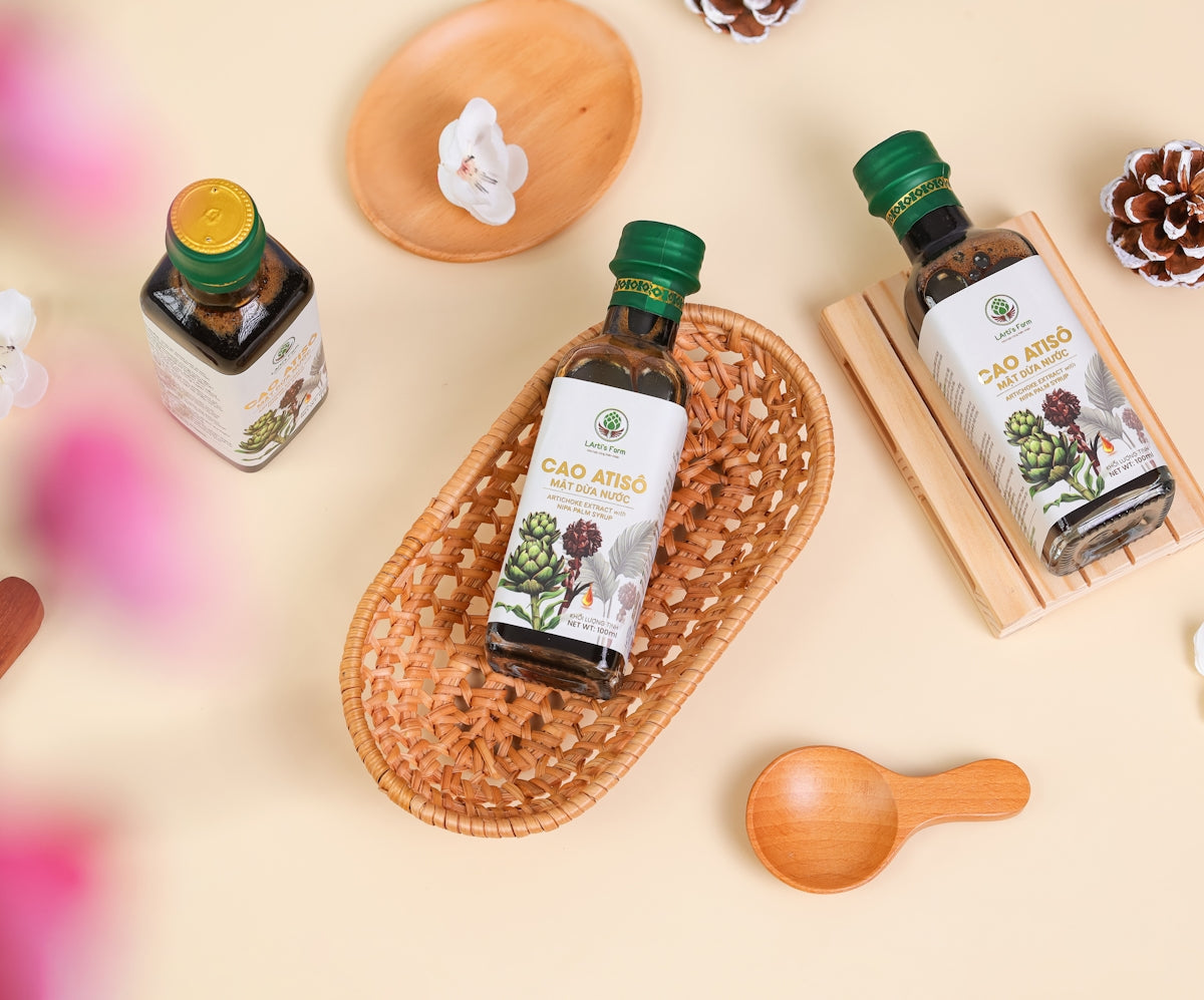 A hand holding a wooden spoon next to some bottles